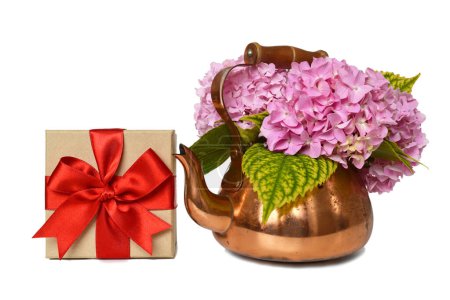 Foto de Gift box and flowers in vintage copper kettle isolated on white background - Imagen libre de derechos