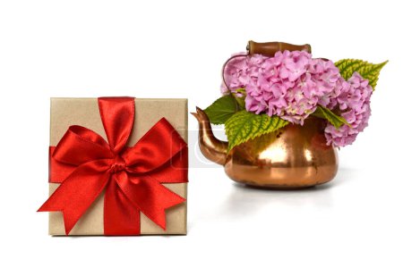 Gift box and flowers in vintage copper kettle isolated on white background