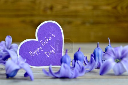Téléchargez les photos : Heureux texte de la fête des pères écrit sur étiquette en forme de coeur et fleurs violettes - en image libre de droit