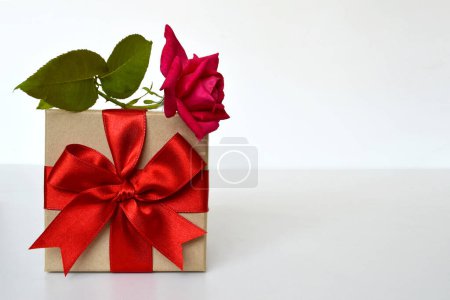 Foto de Caja de regalo y rosa roja sobre fondo blanco, regalo romántico - Imagen libre de derechos
