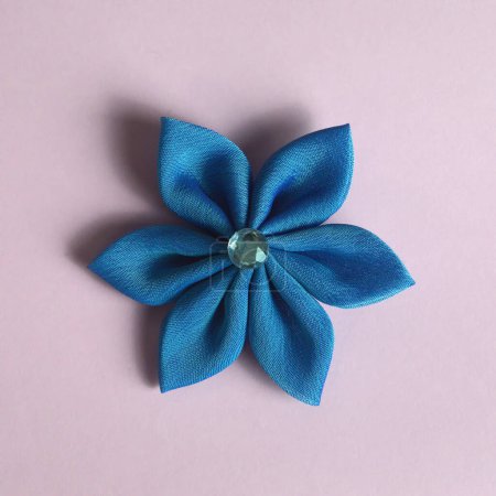 Blue kanzashi flower on pink background