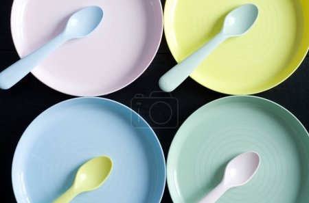 Photo for Macro Image of Pink, Yellow, Blue and Green Baby Plates and Spoons Horizontal - Royalty Free Image
