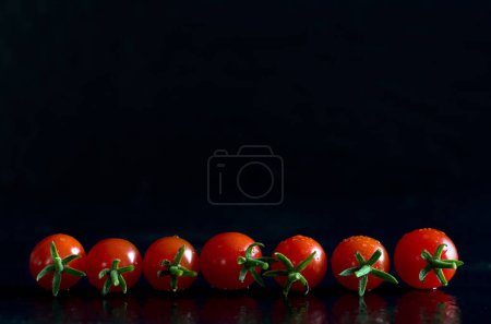 Téléchargez les photos : Macro Image de petites tomates rouges sur fond noir Horizontal - en image libre de droit