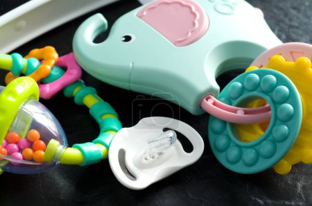 Téléchargez les photos : Macro Image de bébé tétine avec des jouets colorés sur fond noir Horizontal - en image libre de droit