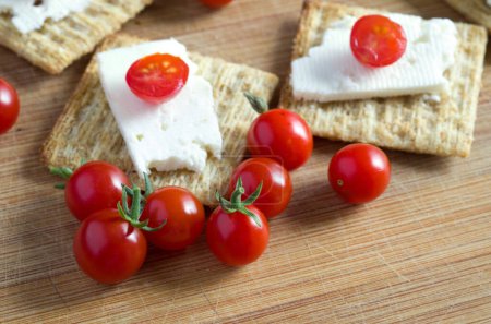 Téléchargez les photos : Macro Image de bébé tomates rouges au fromage feta et craquelins sur bois Horizontal - en image libre de droit