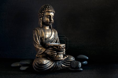 Photo for Bronze Gautama Buddha with Dark Rocks Isolated on Black Horizontal - Royalty Free Image