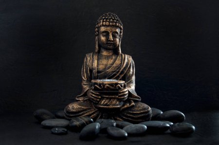 Photo for Bronze Gautama Buddha with Dark Rocks Isolated on Black Horizontal - Royalty Free Image