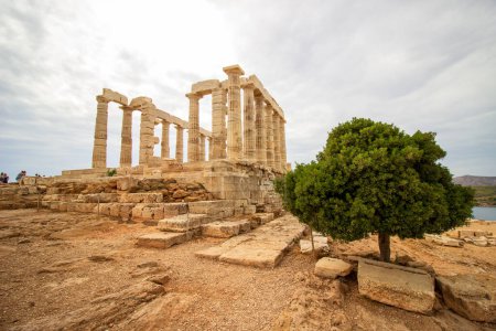 Majestuosas ruinas del antiguo templo de Poseidón en el cabo Sounion bajo cielos nublados con vistas al mar Egeo. Foto de alta calidad