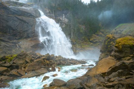 Foto de Krimml Waterfalls, Krimmler Wasserfalle, en el Parque Nacional High Tauern, Austria. El río Krimmler Ache cae. Hermosa cascada dramática en un día lluvioso brumoso. Senderismo en los Alpes austríacos - Imagen libre de derechos