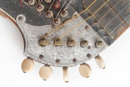 Foto de Top closeup horizontal studio shot of vintage, old wooden zither isolated on white background. Detail of zither mechanics and tuning pins. Dusty and scratched musical instrument - Imagen libre de derechos