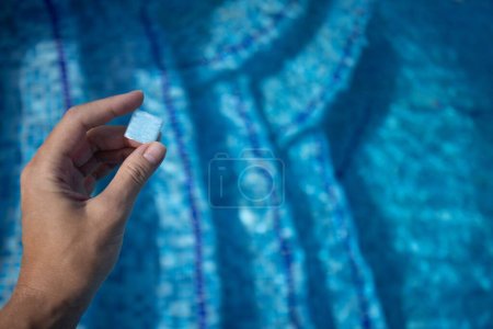 Photo for Hand holding small tile from floor of swimming pool. Design of the swimming pool - Royalty Free Image