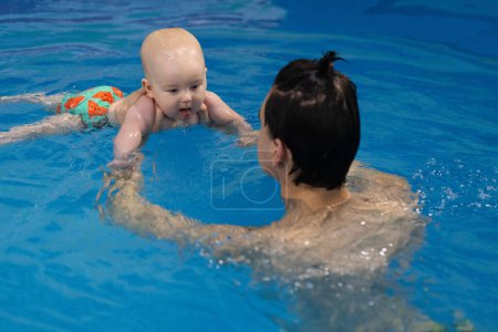 Baby coughing after diving under water. Lessons of diving under water with a newborn