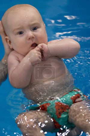 Baby knallt nervös mit den Fingerknöcheln im Wasser. Nahaufnahme.