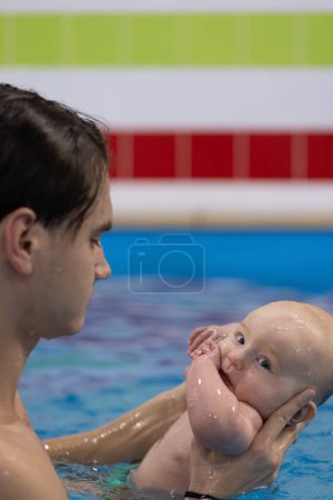 Schwimmunterricht mit dem Neugeborenen in einem Schwimmbad. Nahaufnahme
