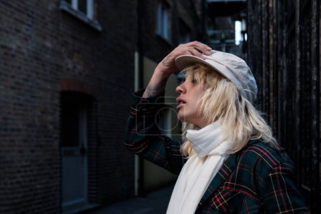 Téléchargez les photos : Tête d'une jeune femme alternative posant dans une rue londonienne. Ses yeux sont fermés et elle montre son côté. - en image libre de droit
