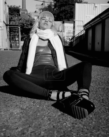 Téléchargez les photos : Portrait of alternative woman sitting on the street floor. Film analog camera. Monochrome. - en image libre de droit