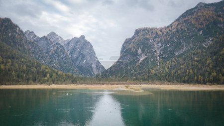 Photo for Greenish alpine lake surrounded by mountains during autumn season, Italy, Europe. - Royalty Free Image
