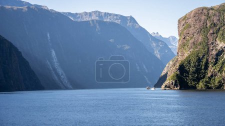 Ausflugsboote segeln durch Fjord mit steilen Felswänden, Fiordland, Neuseeland.