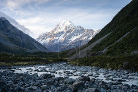 Alpine valley with glacial river flowing through and prominent peak in backdrop during sunset,Aoraki.