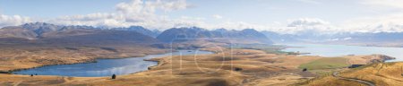 Weites Panorama der typischen neuseeländischen Landschaft mit alpinen Seen, sanften Hügeln, großen Gebirgsketten.