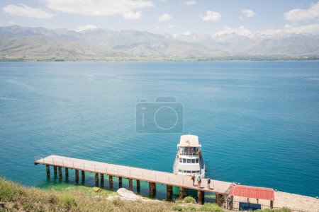 Photo for Tourists on the pier waiting for their boat with beautiful lake and mountains in backdrop, Turkey. - Royalty Free Image