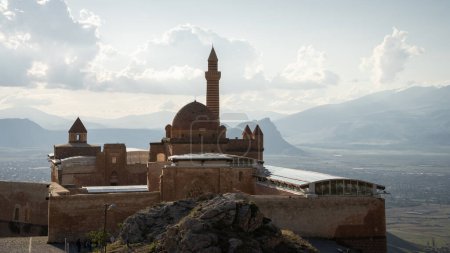 Historical Arabian palace with minarets overlooking city in the valley beneath, Eastern Turkey.