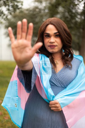 Trans-Frau macht Stoppschild und hält Trans-Flagge. Hochwertiges Foto