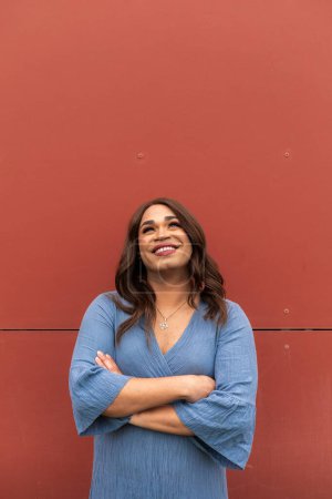 Photo for Trans woman looking up on a red background. Copy space, vertical shot. High quality photo - Royalty Free Image