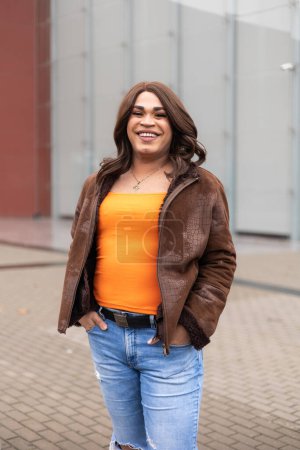 Erfolgreiche und selbstbewusste Transfrau, die glücklich in die Kamera lächelt. Lateinische Volkszugehörigkeit. Hochwertiges Foto