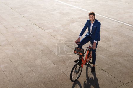 Portrait of latin businessman riding an electric bike at sunset. Sustainable lifestyle. . High quality photo