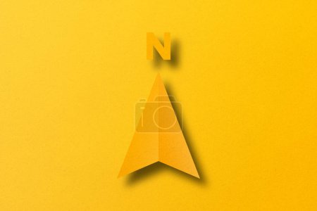 Photo for Yellow paper cut in shape, north arrow set on yellow paper background. - Royalty Free Image