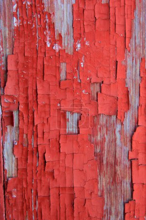 Paint peeling off the wooden board, red