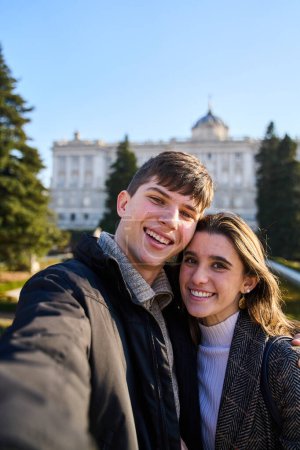 Junges Paar beim Besuch des Königspalastes in Madrid und macht ein Selfie mit seinem Smartphone