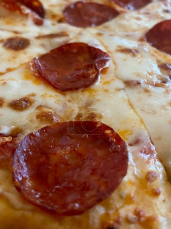Close-up of slice of pizza with salami and cheese