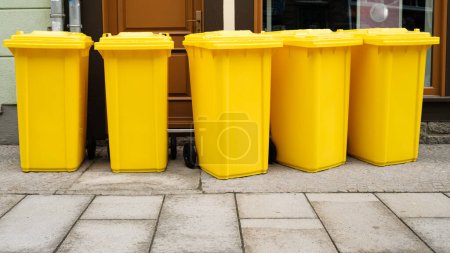 Téléchargez les photos : Rangée de poubelles jaunes dans la rue - en image libre de droit