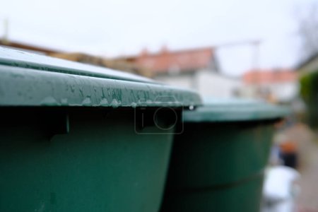 Téléchargez les photos : Conteneurs à ordures humides sur la rue - en image libre de droit