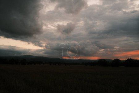 Téléchargez les photos : Beau ciel nuageux au-dessus du champ à la campagne au coucher du soleil - en image libre de droit