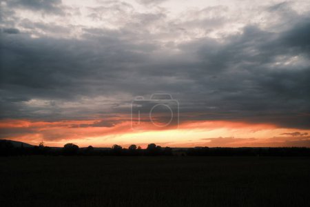 Téléchargez les photos : Beau ciel nuageux au-dessus du champ à la campagne au coucher du soleil - en image libre de droit