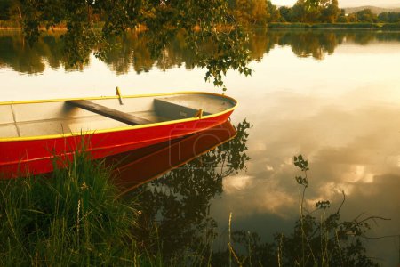 Téléchargez les photos : Un beau cliché d'un bateau sur le lac au coucher du soleil - en image libre de droit