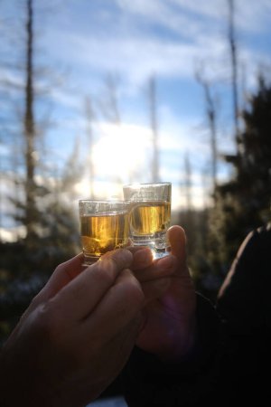 Foto de Personas tintineo gafas en borrosa bosque de invierno fondo - Imagen libre de derechos