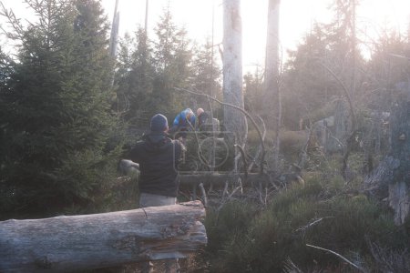 Téléchargez les photos : Groupe de touristes avec sacs à dos randonnée à travers la forêt d'automne - en image libre de droit