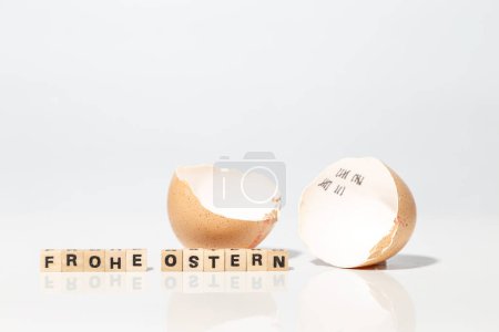 Foto de Huevo roto y bloques de madera con feliz texto de Pascua - Imagen libre de derechos