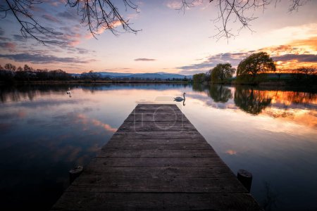 Téléchargez les photos : Un beau coucher de soleil sur le lac le soir avec des reflets - en image libre de droit