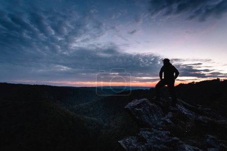 Foto de Joven excursionista disfrutando de la puesta de sol en las montañas - Imagen libre de derechos