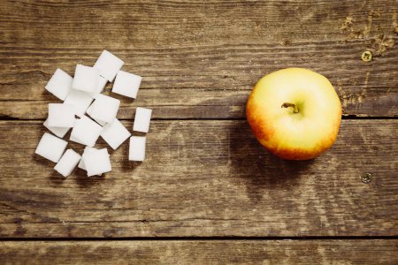 Photo for Apple and sugar cubes on wooden table - Royalty Free Image