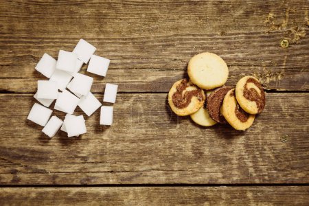 Téléchargez les photos : Biscuits et cubes de sucre sur table en bois - en image libre de droit