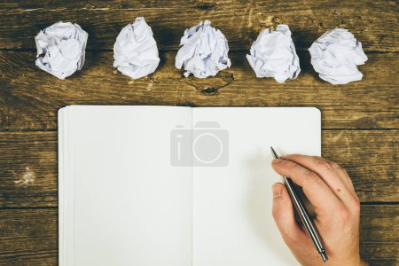 Téléchargez les photos : Vue de dessus des mains d'homme d'affaires écrivant sur le bloc-notes - en image libre de droit