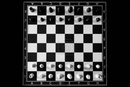 Foto de Tablero de ajedrez con piezas de ajedrez sobre fondo negro - Imagen libre de derechos