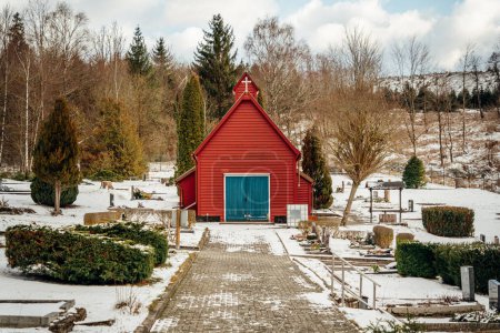 Téléchargez les photos : Église rouge avec porte bleue dans la neige dans le paysage rural d'hiver - en image libre de droit