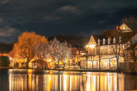 Téléchargez les photos : Illumination de la petite ville d'Ilsenburg reflétée dans l'eau - en image libre de droit